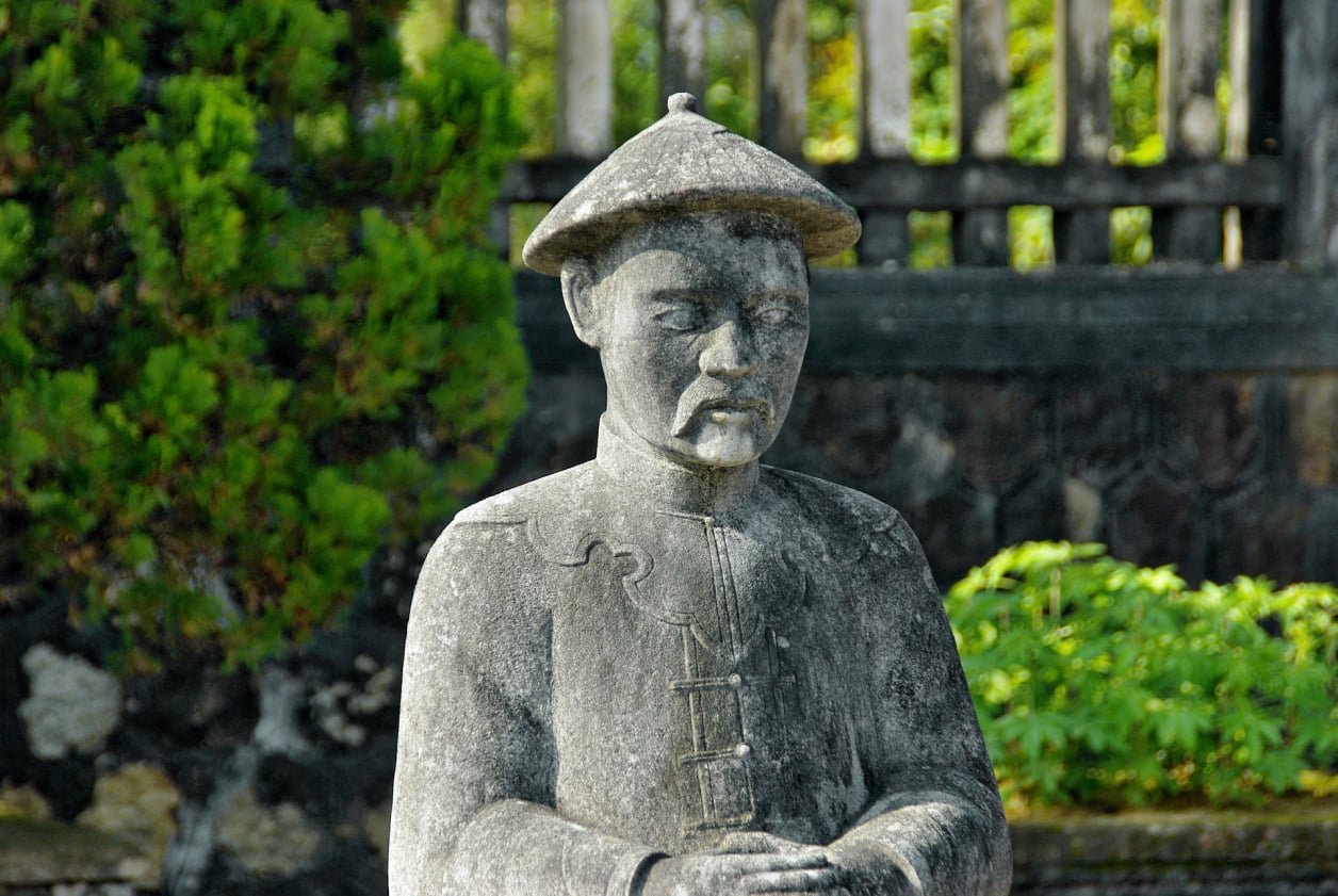A statue of a Chinese sage in an Oriental garden