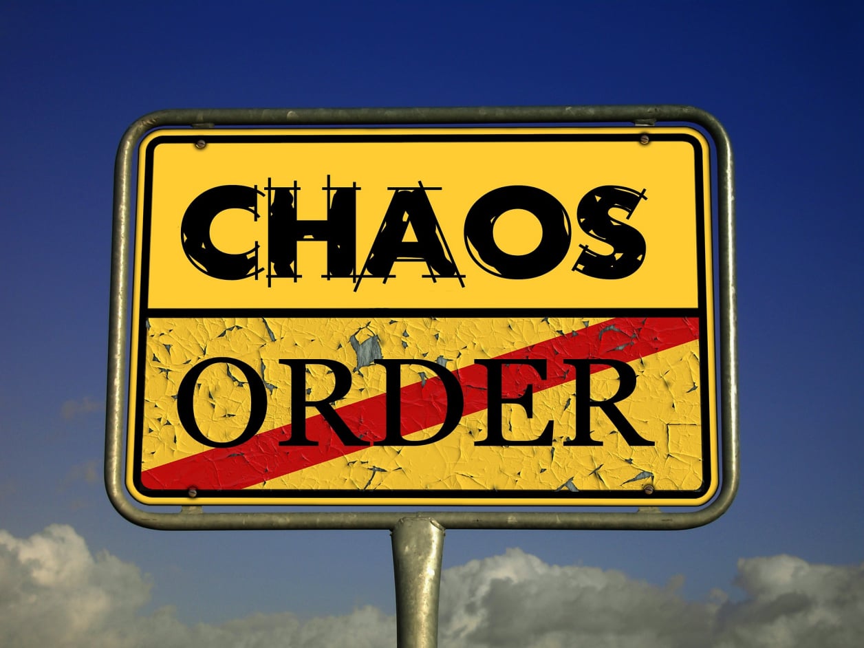 A sign showing the words Chaos and Order, with a line through Order